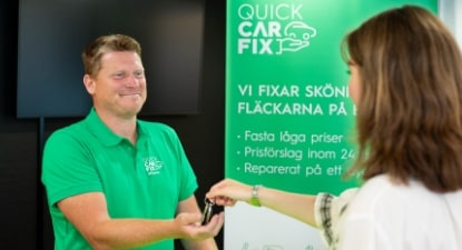 En kvinna räcker bilnycklar till en man. En kvinna räcker bilnycklar till en man.
