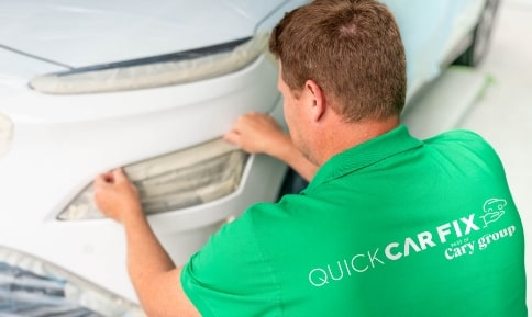 Quick Carfix En mand i grøn skjorte maler en bil.